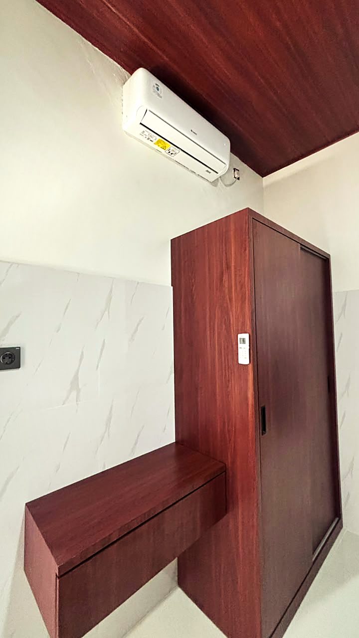 Lemari pakaian sliding, meja rias gantung, dan AC di kamar Yka Residence Jimbaran (foto asli)